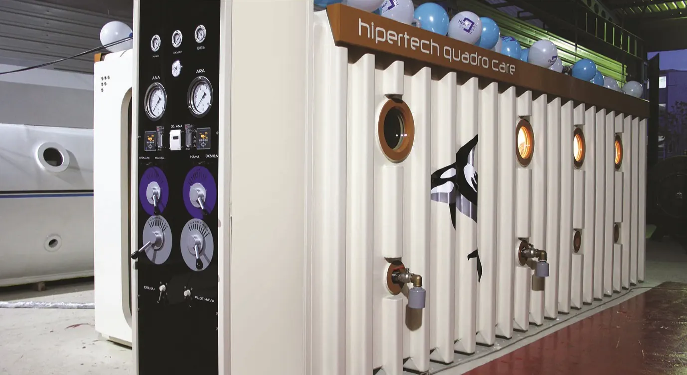 The flank of a Multiplace Quadro clad in fluted cream panels with bronze-rimmed viewports, under a lit header reading hipertech quadro care