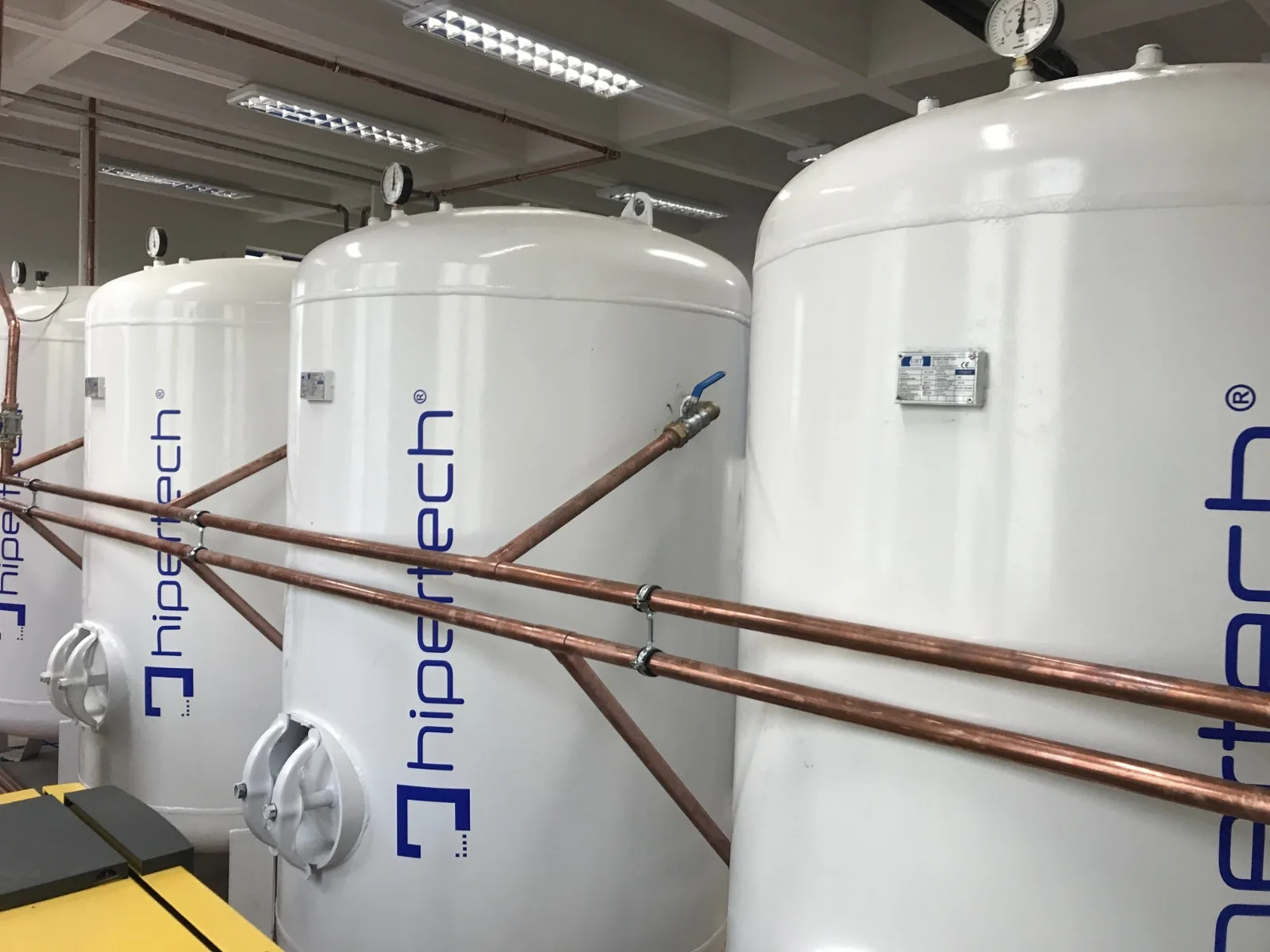 Four Hipertech-branded air storage vessels with copper piping, part of a chamber system build